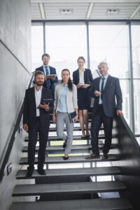 Portrait of confident businesspeople standing on staircase in office